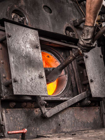 Loading the boiler of an old steam trainの写真素材