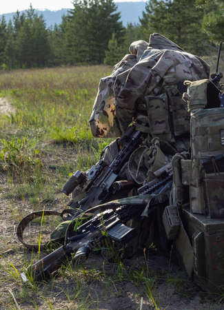 Rifles, camouflage backpack and uniform, ammunition, radio, box on military range, army weapon of...