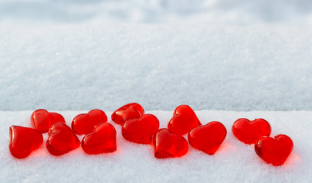 Red glass hearts on snow bench at cold winter, love symbol, Valentines Day holiday concept, top viewの写真素材