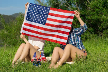 Two woman with USA flags, celebration of patriotic american national holiday 4th of july...