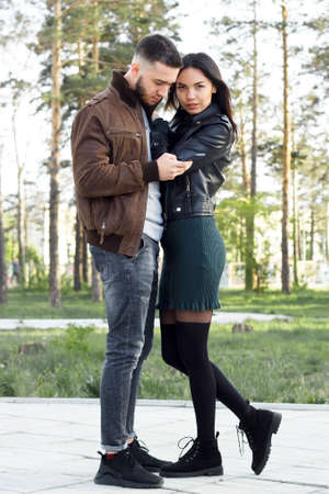 Beautiful couple in love on romantic dating in summer city park, sensual relationship of young man and woman, candid lifestyle, vertical imageの写真素材