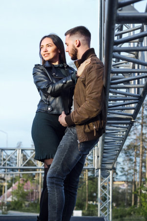 Date romance of couple in love with industrial style, young happy attractive man and woman dating at steel construction, casual lifestyle, vertical imageの写真素材