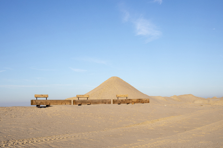 Three benches made of sturdy woodblocks in a landscape of dunes, sand and a blue sky at the Markerwadden in the Netherlands, Hollandの写真素材