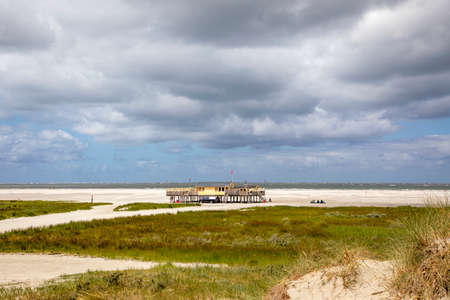 Beach pavilion on the beach of Schiermonnikoog on the North Sea side seen from the dunesの写真素材