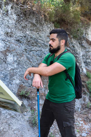 Man looking for information in a panel during a hiking dayの写真素材