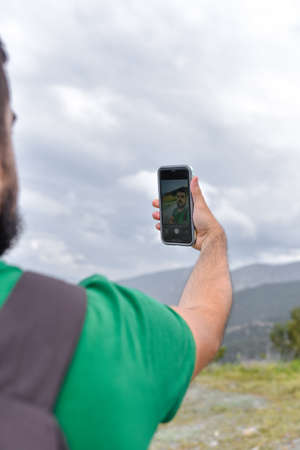 Stock photo of a closeup of the arm of a young man taking a selfieの写真素材