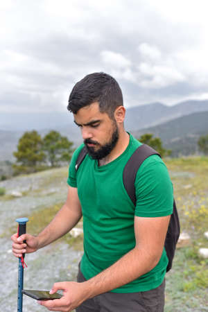Man in the nature looking the screen of his smartphoneの写真素材