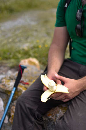 Stock photo of unrecognizable man with a closeup of a banana in the handsの写真素材