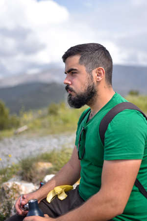 Man taking a break after eating a banana on a hiking dayの写真素材