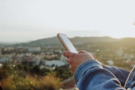 young lady using cell phone on the countryside. Rural internet connectivity concept.の写真素材