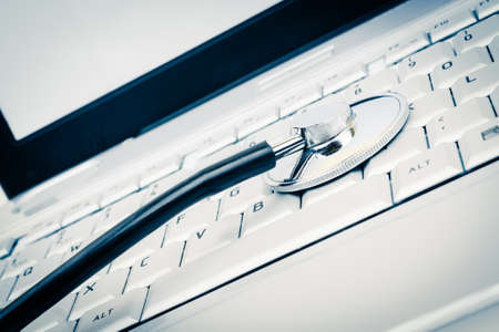 blue selective focus image of stethecope on laptop keyboardの写真素材