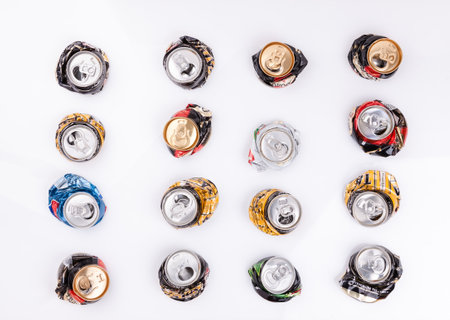 Crushed disposable beer drink cans aluminum on white table background as tins recycling conceptの写真素材