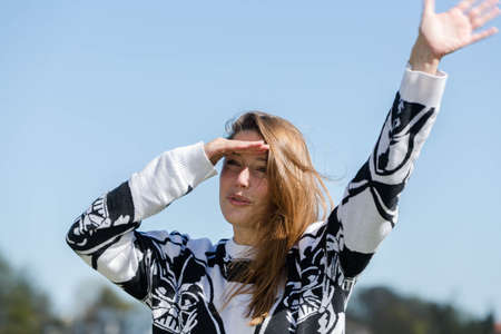 Woman looking into the distance, waving to their friends as a greetingの写真素材