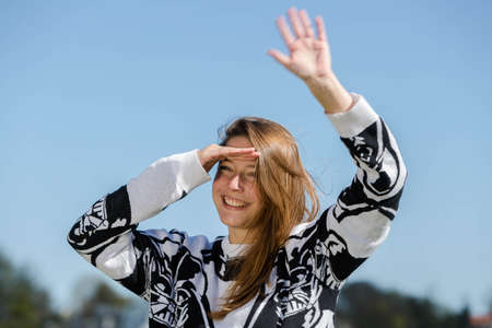 Young woman enjoying a laugh on the return of their friend and greeted him wavingの写真素材