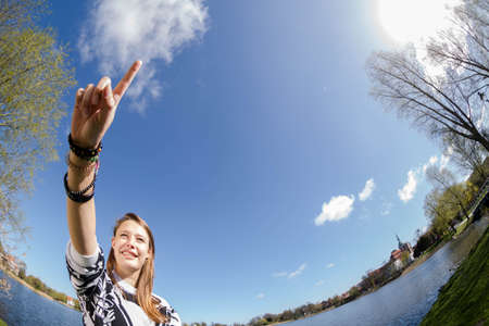 A student is laughing forward with her forefinger in sunshineの写真素材