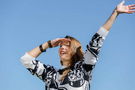 A young woman looks ahead and recognizes their friends with anticipationの写真素材