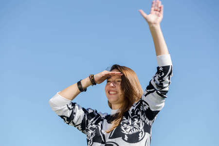 A young woman looks ahead and waves a hand full of anticipationの写真素材