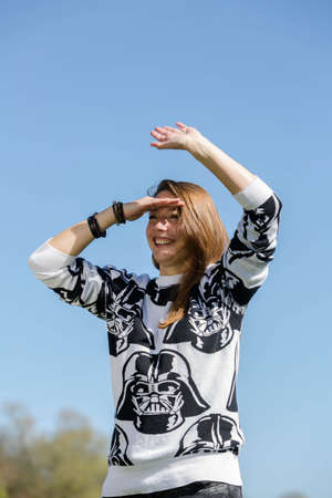 A young woman looks ahead and waves a hand full of anticipationの写真素材