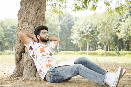 college boy relaxing in a parkの写真素材