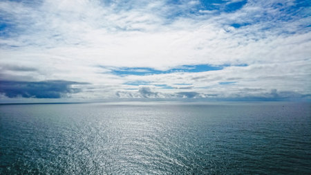Cape Roca, Sintra, Portugal - June 3, 2018: view of the peaceful Atlantic Ocean with waves and under a cloudy blue skyの写真素材