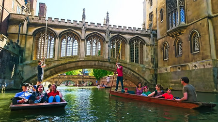Cambridge, UK - May 5, 2018: Young men punting on the River Cam in front of the Bridge of Sighsのeditorial素材