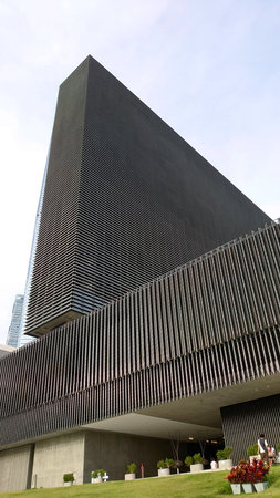 Hong Kong - 08.29.2021: Close-up of the exterior of Mplus museum under a bright sky with lawn and...