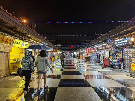 Hualien, Taiwan - 11.24.2022: A few customers browsing the market stalls in Dongdamen Night Market in Hualien during the pandemic on a rainy nightのeditorial素材
