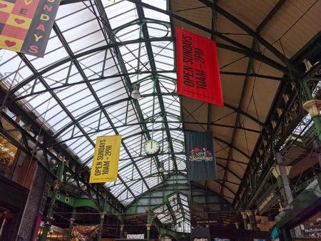 London, UK - 10.02.2021: Interior ceiling of the Borough Market with banners hanging down under green steel structure with sunlight coming throughのeditorial素材