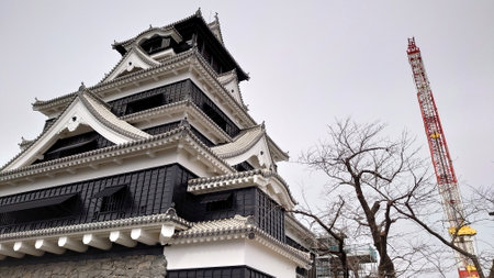 Kumamoto, Japan - 01.26.2020: Close-up of Kumamoto Castle under reconstruction work after the 2016 earthquake with scaffolds and a crane in sight under a cloudy skyのeditorial素材
