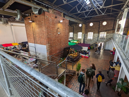 London, UK - 04.03.2022: People browsing food stalls in the Truman Markets within the redbrick building with sunlight coming through the windows during the pandemic, viewed from the second floorのeditorial素材