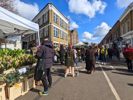 London, UK - 04.03.2022: People buying potted plants and bouquets from street vendors with flowers...