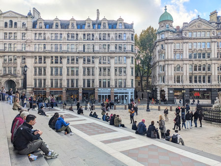 People relaxing on the steps of St Pauls Churchyard next to St. Pauls Cathedral in Londonのeditorial素材