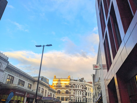 Historic Farringdon Station facade contrasts with modern architecture under a golden hour skyのeditorial素材