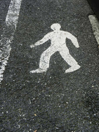 Street sign of pedestrian lane painted in white on gray pavementの写真素材