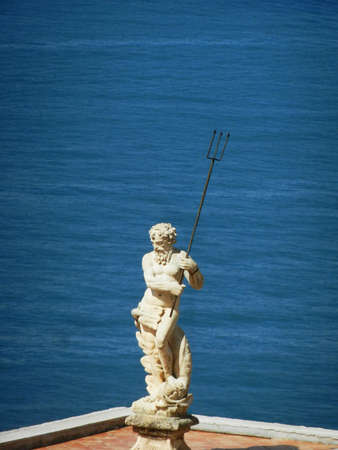 Marble Neptune sculpture with blue sea as backgroundの写真素材