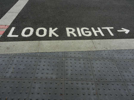 Warning sign white letters on pavementの写真素材