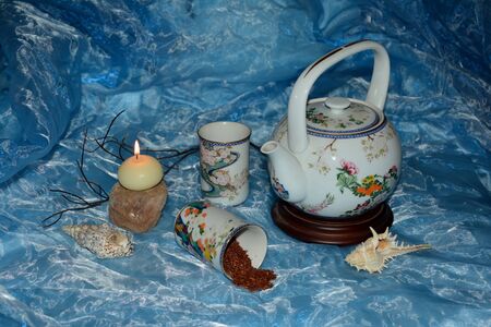Teapot, tea and tea with candle on Light Blue Backgroundの写真素材