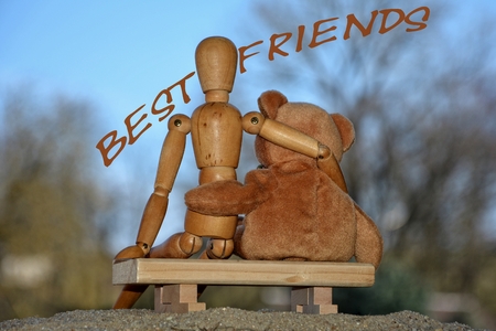 Best friends on bench in back view with letteringの写真素材