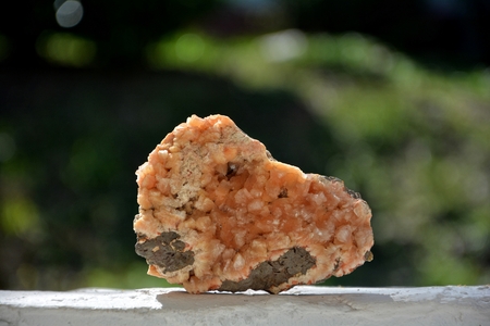 Orange quartz mineral stone on white wall with dark backgroundの写真素材