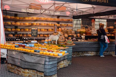 Sales booth with many different types of cheese in Middelburg, the Netherlands on August 12, 2017, with a womanのeditorial素材