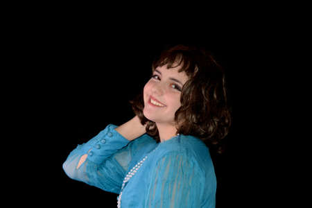 Portrait of a young woman in blue dress and brown hair, from front and laughing, with black...