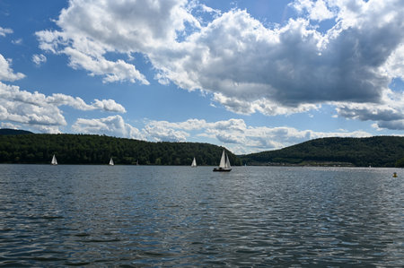 View of the lake Edersee with sailing boats, blue sky and clouds, in Hesse, Germanyのeditorial素材