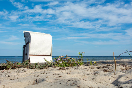 Sandy beach with blurred white traditional wicker beach baskets   in the background, on Poel, Germanyの写真素材