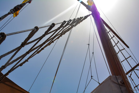 Mast of a sailing ship with no sails set with blue skyの写真素材