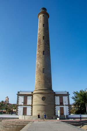 Lighthouse in Maspalomas ( Faro de Maspalomas ) on the Canary Island of Gran Canaria in Spain with palm treeの写真素材