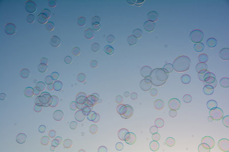 Many colorful soap bubbles float in the sky