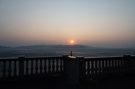 View from a terrace with column railing to the sea and the island of KRK in Croatia, Europe, at sunsetの写真素材