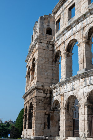 Part of the Pula Arena, the sixth largest amphitheater of its kind, with a blue sky in Croatia,...