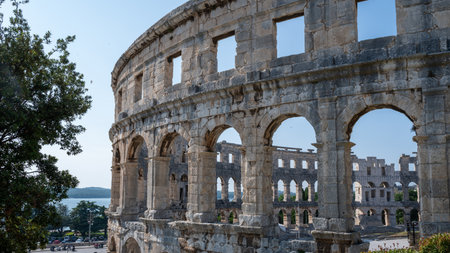Part of the Pula Arena, the sixth largest amphitheater of its kind, with a blue sky in Croatia,...