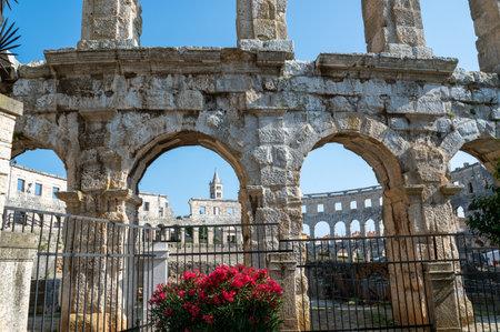 Part of the Pula Arena, the sixth largest amphitheater of its kind, with a blue sky , church and flowers  in Croatia, Europeの写真素材
